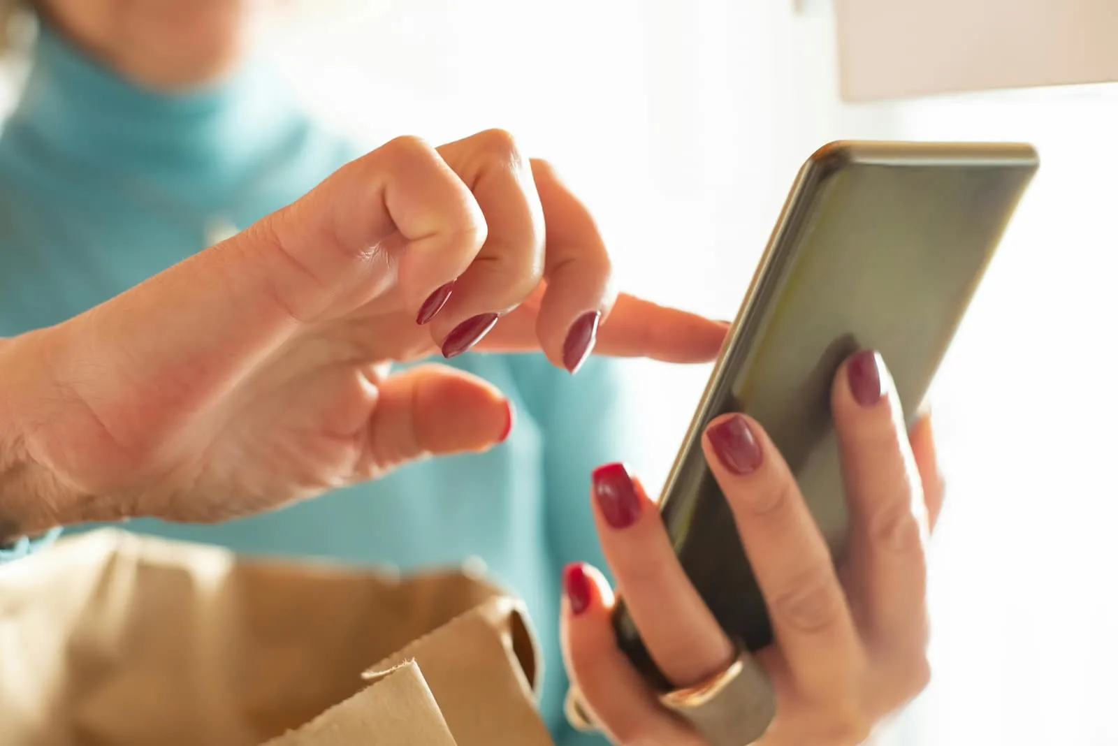A woman touches the screen of a smartphone with her index finger.