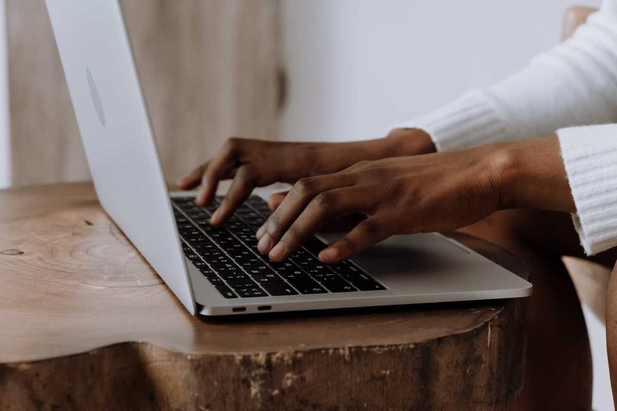 Closeup of a person's hands typing on a laptop keyboard