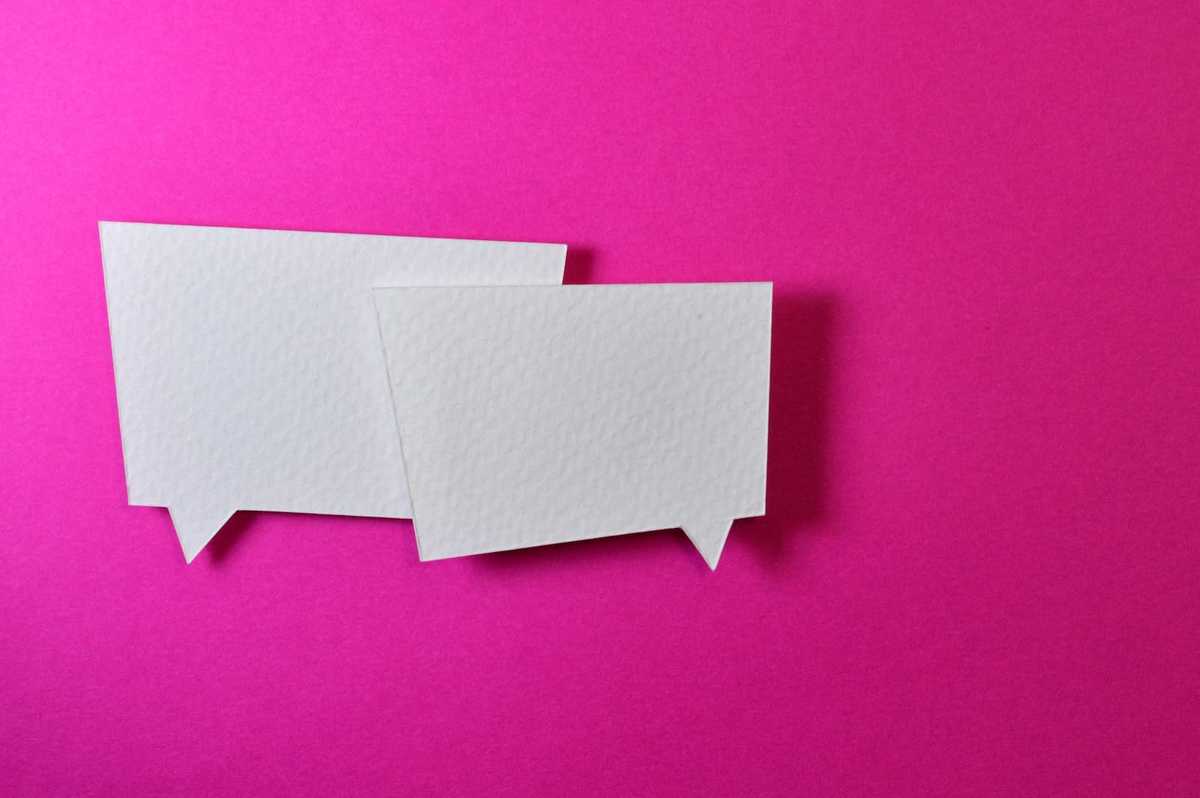 Two white speech bubbles on a pink background.